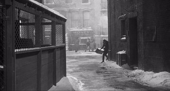 Movie still from “Some Like It Hot” (1959), directed by Billy Wilder – A person walking down a street in the snow; Extreme Wide shot, High angle
