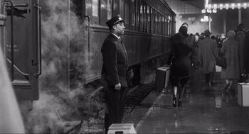 Movie still from “Some Like It Hot” (1959), directed by Billy Wilder – A train conductor standing next to a train car; Wide shot, Low angle