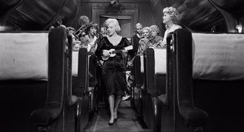 Movie still from “Some Like It Hot” (1959), directed by Billy Wilder – A woman walking down the aisle of an airplane; Wide shot, High angle