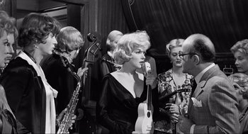 Movie still from “Some Like It Hot” (1959), directed by Billy Wilder – A group of people that are standing around each other; Medium shot, Over the shoulder angle