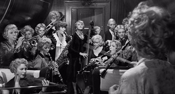 Movie still from “Some Like It Hot” (1959), directed by Billy Wilder – A group of women are playing musical instruments together; Wide shot, High angle