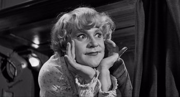 Movie still from “Some Like It Hot” (1959), directed by Billy Wilder – An old photo of an older woman with curly blonde hair; Close Up shot, Low angle
