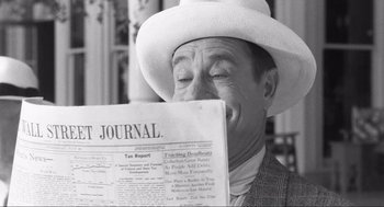 Movie still from “Some Like It Hot” (1959), directed by Billy Wilder – A black and white photo of a man reading a newspaper; Close Up shot, Over the shoulder angle