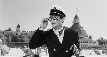Movie still from “Some Like It Hot” (1959), directed by Billy Wilder – A man in a sailor's hat and glasses looks off to the side; Medium shot, Low angle