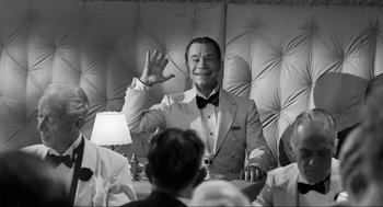 Movie still from “Some Like It Hot” (1959), directed by Billy Wilder – A black and white photo of a man sitting at a table; Medium shot, Over the shoulder angle