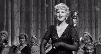 Movie still from “Some Like It Hot” (1959), directed by Billy Wilder – An old photo of a woman in a black dress; Medium shot, Low angle