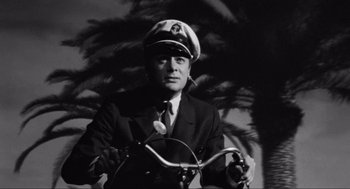 Movie still from “Some Like It Hot” (1959), directed by Billy Wilder – A black and white photo of a man in a suit and a hat; Close Up shot, Low angle