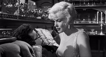 Movie still from “Some Like It Hot” (1959), directed by Billy Wilder – A woman in a white dress is looking at a man in a suit; Medium shot, Over the shoulder angle