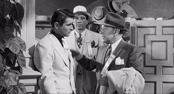 Movie still from “Some Like It Hot” (1959), directed by Billy Wilder – A group of men standing next to each other in a room; Medium shot, Over the shoulder angle