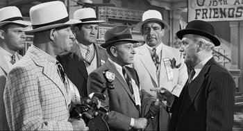 Movie still from “Some Like It Hot” (1959), directed by Billy Wilder – A black and white photo of a group of men in suits and hats; Medium shot, Over the shoulder angle