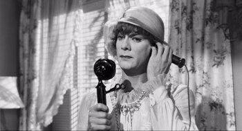 Movie still from “Some Like It Hot” (1959), directed by Billy Wilder – An older woman holding a hair dryer in her hand; Close Up shot, Over the shoulder angle