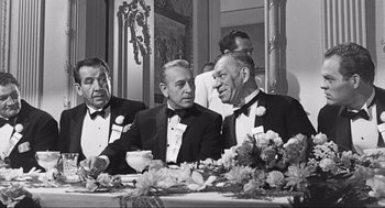 Movie still from “Some Like It Hot” (1959), directed by Billy Wilder – A black and white photo of men in tuxedos sitting at a table; Medium shot, Over the shoulder angle