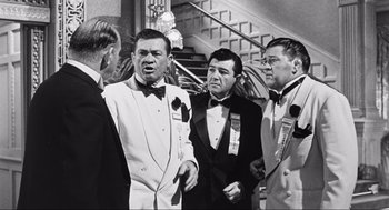 Movie still from “Some Like It Hot” (1959), directed by Billy Wilder – A black and white photo of a group of men in tuxedos; Medium shot, Over the shoulder angle