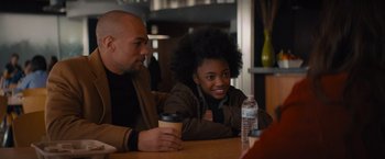 Movie still from “Something from Tiffany's” (2022), directed by Daryl Wein – A man and a woman sitting at a table with a cup of coffee; Medium shot, Over the shoulder angle