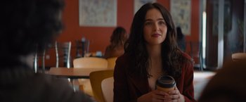Movie still from “Something from Tiffany's” (2022), directed by Daryl Wein – A woman sitting at a table holding a cup of coffee; Close Up shot, Over the shoulder angle