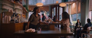 Movie still from “Something from Tiffany's” (2022), directed by Daryl Wein – A woman standing at a counter in front of a person; Medium shot, Over the shoulder angle