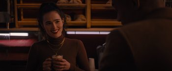 Movie still from “Something from Tiffany's” (2022), directed by Daryl Wein – A woman in a brown sweater holding a cup of coffee; Medium shot, Over the shoulder angle
