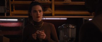 Movie still from “Something from Tiffany's” (2022), directed by Daryl Wein – A woman holding a wine glass in her hands; Close Up shot, Over the shoulder angle