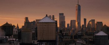 Movie still from “Something from Tiffany's” (2022), directed by Daryl Wein – A view of a city skyline with a water tower in the foreground at sunset; Extreme Wide shot, Low angle