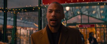 Movie still from “Something from Tiffany's” (2022), directed by Daryl Wein – A man in a brown jacket is looking at the camera; Close Up shot, Over the shoulder angle