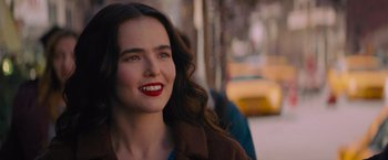 Movie still from “Something from Tiffany's” (2022), directed by Daryl Wein – A beautiful young lady with red lipstick smiling for the camera; Close Up shot, Over the shoulder angle