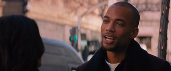 Movie still from “Something from Tiffany's” (2022), directed by Daryl Wein – A person smiling near a traffic light; Close Up shot, Over the shoulder angle