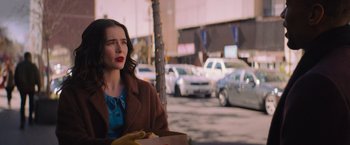 Movie still from “Something from Tiffany's” (2022), directed by Daryl Wein – A woman sitting on the side of the street eating a hot dog; Medium shot, Over the shoulder angle