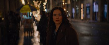 Movie still from “Something from Tiffany's” (2022), directed by Daryl Wein – A woman with red lipstick standing in the rain; Close Up shot, Over the shoulder angle