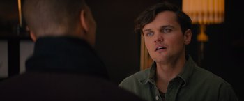 Movie still from “Something from Tiffany's” (2022), directed by Daryl Wein – A man looking into a mirror while standing next to another man; Close Up shot, Over the shoulder angle