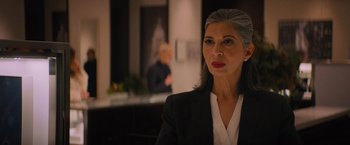 Movie still from “Something from Tiffany's” (2022), directed by Daryl Wein – An older woman in a black suit and white shirt; Close Up shot, Over the shoulder angle