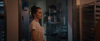 Movie still from “Something from Tiffany's” (2022), directed by Daryl Wein – A woman standing in front of a shelf in a kitchen; Close Up shot, Over the shoulder angle
