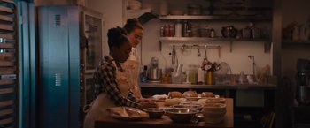 Movie still from “Something from Tiffany's” (2022), directed by Daryl Wein – Two women in a kitchen preparing food; Medium shot, Over the shoulder angle