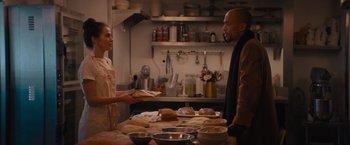 Movie still from “Something from Tiffany's” (2022), directed by Daryl Wein – A man and a woman in a kitchen with food; Medium shot, Over the shoulder angle