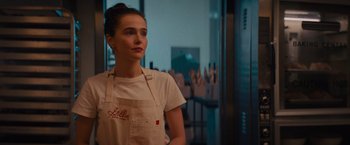 Movie still from “Something from Tiffany's” (2022), directed by Daryl Wein – A woman wearing an apron standing in a room; Close Up shot, Over the shoulder angle