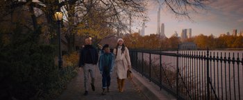 Movie still from “Something from Tiffany's” (2022), directed by Daryl Wein – A man , woman , and a child are walking down a sidewalk; Wide shot, Over the shoulder angle
