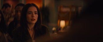 Movie still from “Something from Tiffany's” (2022), directed by Daryl Wein – A woman sitting at a table in front of a lamp; Close Up shot, Over the shoulder angle