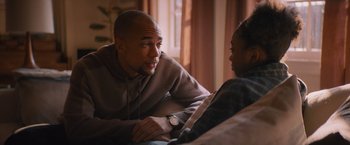 Movie still from “Something from Tiffany's” (2022), directed by Daryl Wein – A man talking to a woman on a couch; Medium shot, Over the shoulder angle