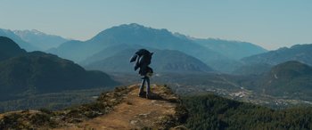 Movie still from “Sonic the Hedgehog” (2020), directed by Jeff Fowler – A man standing on top of a mountain holding an umbrella; Extreme Wide shot, High angle