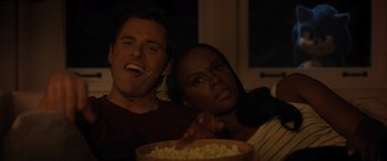 Movie still from “Sonic the Hedgehog” (2020), directed by Jeff Fowler – A man and a woman sitting in front of a bowl of popcorn; Close Up shot, High angle