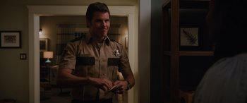 Movie still from “Sonic the Hedgehog” (2020), directed by Jeff Fowler – A man in a sheriff's uniform is holding a paper; Medium shot, Over the shoulder angle