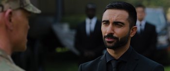 Movie still from “Sonic the Hedgehog” (2020), directed by Jeff Fowler – A man wearing a suit and tie standing next to another man in a suit and tie; Close Up shot, Over the shoulder angle