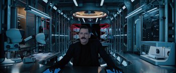 Movie still from “Sonic the Hedgehog” (2020), directed by Jeff Fowler – A man sitting at a table in a spaceship; Medium shot, Low angle