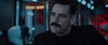 Movie still from “Sonic the Hedgehog” (2020), directed by Jeff Fowler – A man with a handlebar mustache looks to his left; Close Up shot, Over the shoulder angle