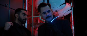 Movie still from “Sonic the Hedgehog” (2020), directed by Jeff Fowler – A man with a beard and a mustache in a room with neon lights; Close Up shot, Low angle