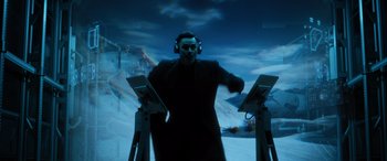 Movie still from “Sonic the Hedgehog” (2020), directed by Jeff Fowler – A man wearing headphones standing in front of a screen; Medium shot, Low angle