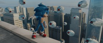 Movie still from “Sonic the Hedgehog” (2020), directed by Jeff Fowler – A sonic the hedgehog standing on top of a building; Wide shot, Low angle