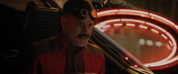 Movie still from “Sonic the Hedgehog” (2020), directed by Jeff Fowler – A man with a beard wearing goggles and a red jacket; Close Up shot, Over the shoulder angle