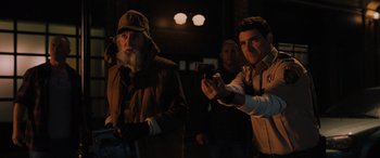 Movie still from “Sonic the Hedgehog” (2020), directed by Jeff Fowler – A group of men standing next to each other in the dark; Medium shot, Over the shoulder angle