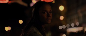 Movie still from “Sonic the Hedgehog” (2020), directed by Jeff Fowler – A woman with long black hair standing in the dark with lights in the background; Close Up shot, Over the shoulder angle