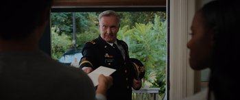 Movie still from “Sonic the Hedgehog” (2020), directed by Jeff Fowler – An older man in a military uniform holding a paper; Medium shot, Over the shoulder angle